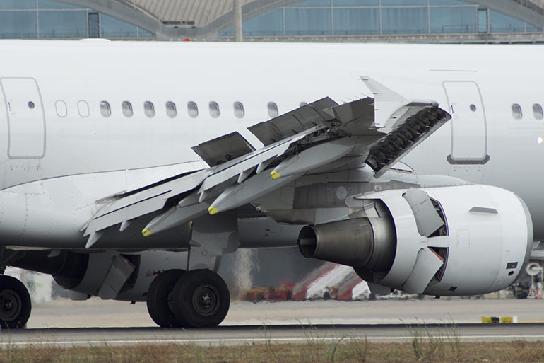 Hydraulic systems play a crucial role in aircraft braking systems, controlling the pressure applied to the brakes to ensure smooth and safe deceleration. Part of the high-speed braking of an aircraft comes from spoilers on the wings as seen here.